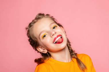 Güzel görünümlü, sevimli, sevimli, neşeli, neşeli, zeki kız yeni bir fikir üretiyor. Fotokopi alanı, izole edilmiş pembe pastel arka plan fantezisi kuruyor.