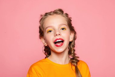 Güzel görünümlü, sevimli, sevimli, neşeli, neşeli, zeki kız yeni bir fikir üretiyor. Fotokopi alanı, izole edilmiş pembe pastel arka plan fantezisi kuruyor.