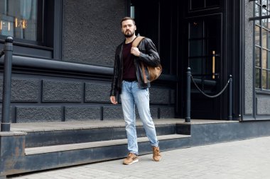 Sokakta deri ceketli, sakallı şık bir adam. Sokaktaki fotoşopçular. Modaya uygun bir adam. Zarif erkek saç stili.