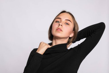 Modayı takip eden güzel hippi kız. Siyah diz boyu çoraplı, beyaz arka planda pozitif genç bir kadının fotoğrafı. Kameraya bak..