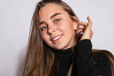 Modayı takip eden güzel hippi kız. Siyah diz boyu çoraplı, beyaz arka planda pozitif genç bir kadının fotoğrafı. Kameraya bakıyor ve gülümsüyor.