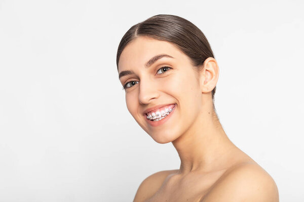 Close up portrait of Smiling Teen girl showing dental braces.Isolated on white background.