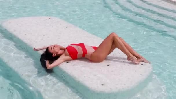 一个性感漂亮的女人在游泳池边晒日光浴性感 — 图库视频影像