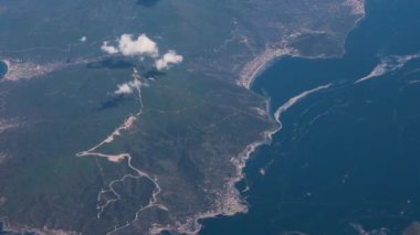 Clouds,view from airplane window, view of fields and meadows. view of the bay with turquoise water. mountain and quarry views