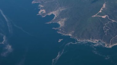 Clouds,view from airplane window, view of fields and meadows. view of the bay with turquoise water. mountain and quarry views
