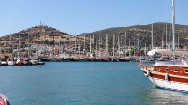Footage of luxury sail boats and yachts at Bodrum marina. It is a famous, popular and touristic summer town located on Aegean side of Turkey. (Southwest) It is a sunny summer day. Camera moves.