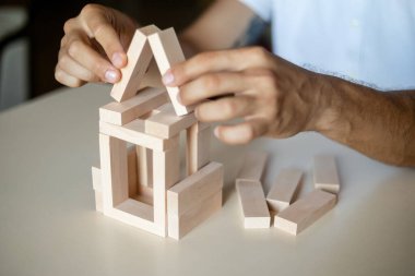İş adamı, iş dünyasındaki konsept risk kontrolü, planlama ve stratejiye tahta blok koyuyor. Alternatif risk konsepti, Buiness Growth Engellerini Ahşap Bloklarla Büyütmek İçin Risk
