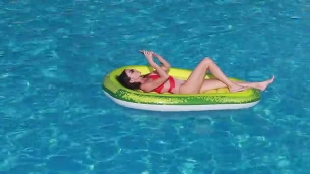 在游泳池用手机在浮动床垫上的女人 女孩放松日光浴享受旅行假期 — 图库视频影像