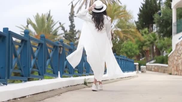 Νεαρή Χαμογελαστή Γυναίκα Φορώντας Λευκό Φόρεμα Ψάθινο Καπέλο Στο Χέρι — Αρχείο Βίντεο