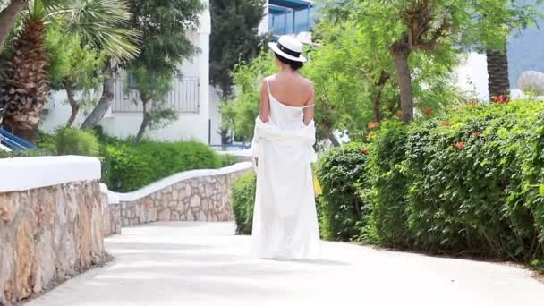 Κινηματογραφική Αργή Κίνηση Νεαρή Γυναίκα Λευκό Φόρεμα Περπατάει Κρατώντας Ένα — Αρχείο Βίντεο