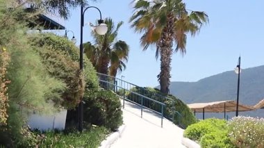 Sabit, sabit bir kumsalın güzel manzarasıyla yürüyorum. Lüks otellerin, bungalovların, turkuaz mavi suların ve palmiye ağaçlarının üzerinde uçuyorlar. Ağır çekim, 4k