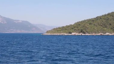Filipinler, Palawan 'daki sahile paralel bir hava uçuşu, arka planda yeşil tepeler ve denizde balıkçı tekneleri, turkuaz su, yavaş çekim, 4k