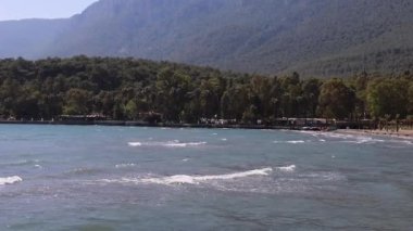 Filipinler, Palawan 'daki sahile paralel bir hava uçuşu, arka planda yeşil tepeler ve denizde balıkçı tekneleri
