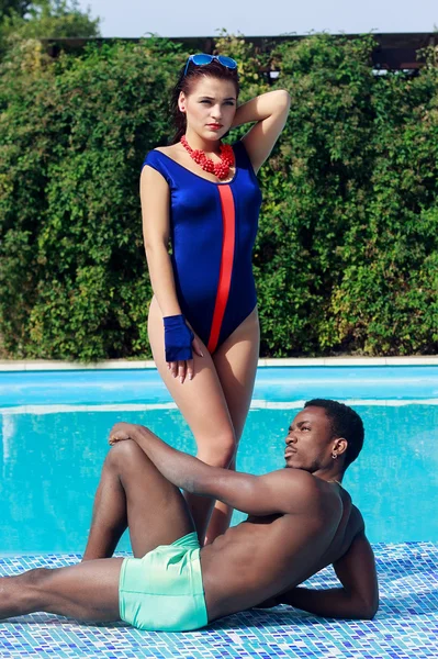 Привлекательная молодая пара в купальниках расслабляющий бассейн на открытом воздухе — стоковое фото