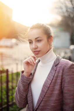 Genç kadın ceket batımında şehir arka plan ile casual ayakta. Seksi çekici moda tonlu görüntü styling 
