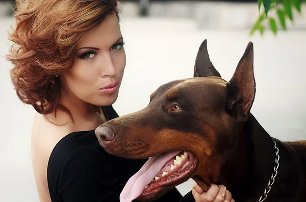 Sexy Frau mit zwei kleinen Dobermann-Hunden. — Stockfoto