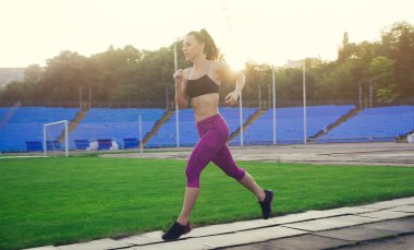 Stadyumda dumbbells ile ince atletik kadın