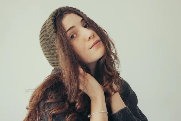 Портрет грайливої жінки в в'язаній зимовій шапці посміхається — стокове фото