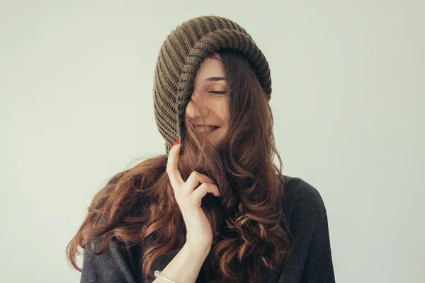 Porträt einer verspielten Frau mit gestrickter Wintermütze, die lächelt — Stockfoto