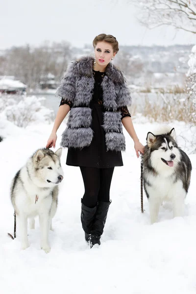 Jeune femme avec chien loup dans la neige — Photo