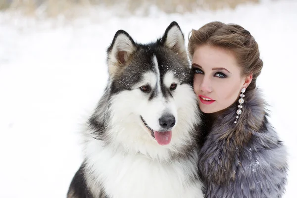 Jeune femme avec chien loup dans la neige — Photo