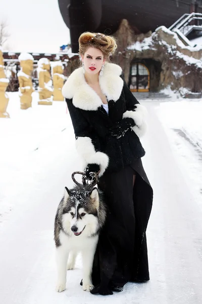 Jeune femme avec chien loup dans la neige — Photo
