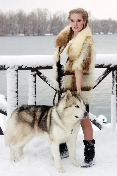 Jeune femme avec chien loup dans la neige — Photo