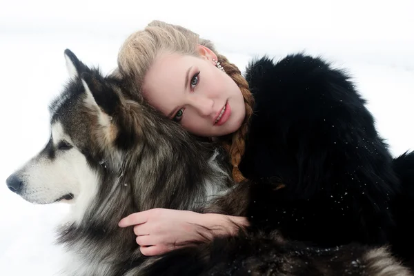 Jovem mulher com cão lobo na neve — Fotografia de Stock