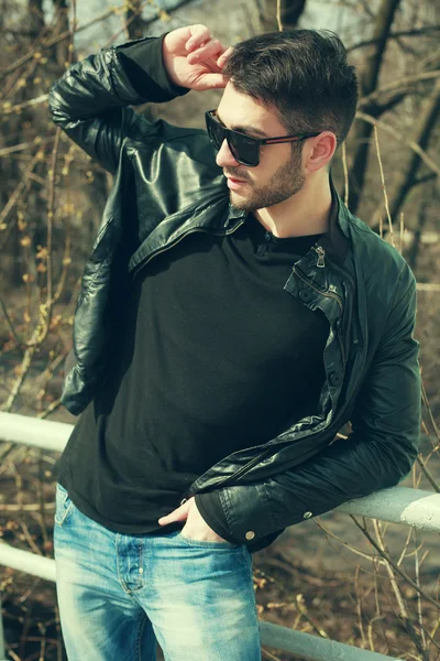Uomo moda giacca di pelle nera, occhiali da sole e jeans — Foto Stock