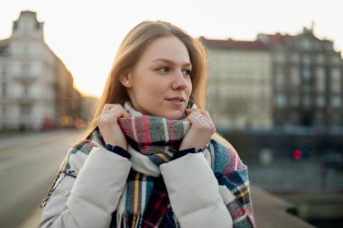 Köprüde duran fularlı ve kahveli kadın, soğuk mevsim kentsel yaşam tarzı.