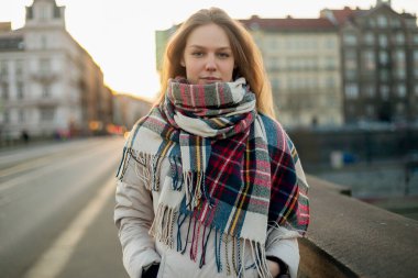 Şehir köprüsünde atkı takan bir kadın, sonbahar moda konsepti..