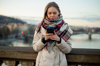 Köprüde telefonu olan bir kadın, modern Avrupa şehir yaşam tarzı..