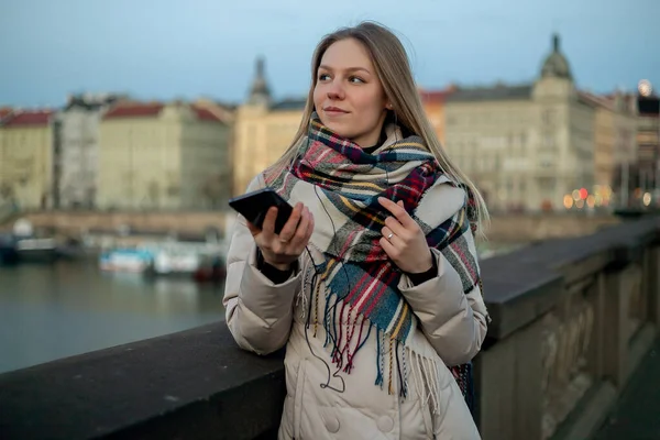Kadın elinde kahve tutarken telefona bakıyor, modern şehir yaşam tarzı..