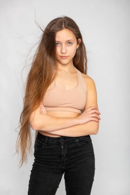 Kendine güvenen stüdyo resmi, bej rengi bluz ve kot, minimalist görünüm tarzı..