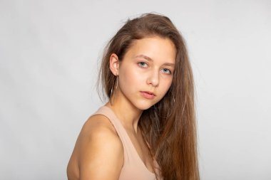 Yan açılı portre, uzun saçlı, asgari güzellik görünüşlü, temiz beyaz arkaplan.