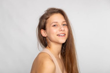 Geniş gülümsemeli mutlu stüdyo portresi, pozitif duygu ve yaşam tarzı markalaşması.