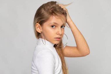 Elleri başının arkasında olan yan portre, rahat bir ruh hali ve temiz bir stüdyo geçmişi var..