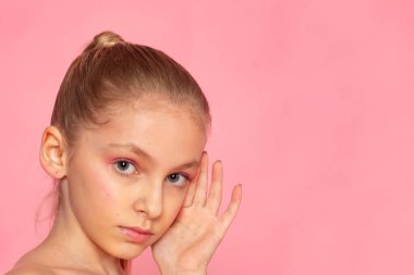 Elleri yanağa yakın güzellik portresi, kendine bakım konsepti ve yumuşak ifade.