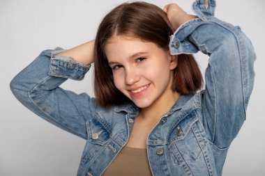 Kafasının arkasında elleri olan oyuncu bir portre, kaygısız bir ruh hali, sıradan bir kot stüdyosu konsepti..