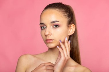 Yüzüne yakın elleri olan güzel bir vesikalık, nazik bir sağlık ve temiz bir güzellik damgası..