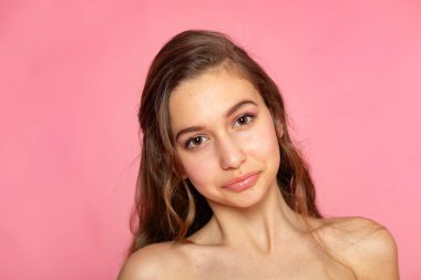 Sakin bir gülümseme ile sakin bir portre, pembe üzerine temiz stüdyo estetiği..