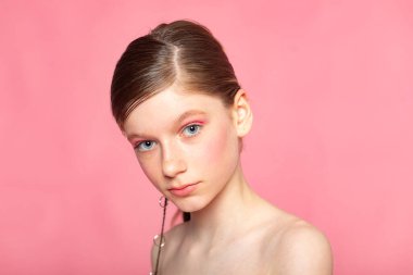 Üçte üç güzellik fotoğrafı, genç kız pembe arka planda hafifçe dönüyor, editör tarzı..