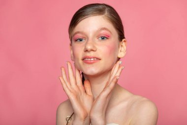 Pembe arka planda gülümseyen güzel bir vesikalık, tertemiz minimal portre..