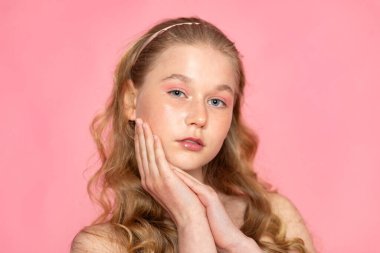 Yanakları çerçeveleyen ellerle güzel bir vesikalık, pastel pembeye yumuşak bir yazı..