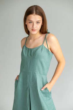 Minimum boy moda portresi, deniz mavisi elbise ve temiz gri arka plan, modern editoryal....