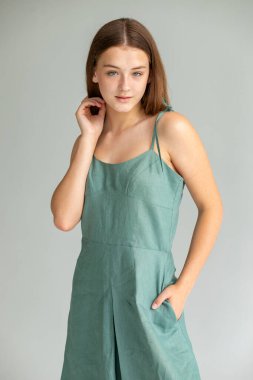 Tam vücut stüdyo çekimi, deniz mavisi elbiseli kadın, temiz zarafet ve modern asgari estetik..