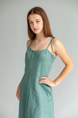 Yan dönmüş vücut portresi, deniz mavisi elbise, modern asgari yayın havası..