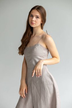 Bej elbiseli şık stüdyo pozu, modern kadın moda konsepti..