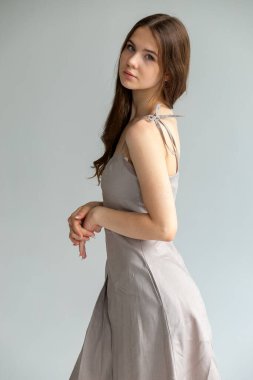 Minimum moda portresi, yumuşak pozlu çıplak kadın, tarafsız stüdyo arka planı..