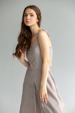 Yan yana tam boy portre, bej iç çamaşırlı kadın, tarafsız arka planda en az moda..